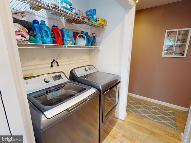 laundry room featuring laundry area, washer and clothes dryer, wood finished floors, and baseboards