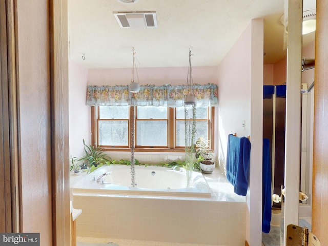 bathroom with visible vents and a garden tub