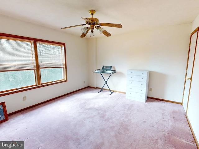 unfurnished room with baseboards, ceiling fan, and light colored carpet