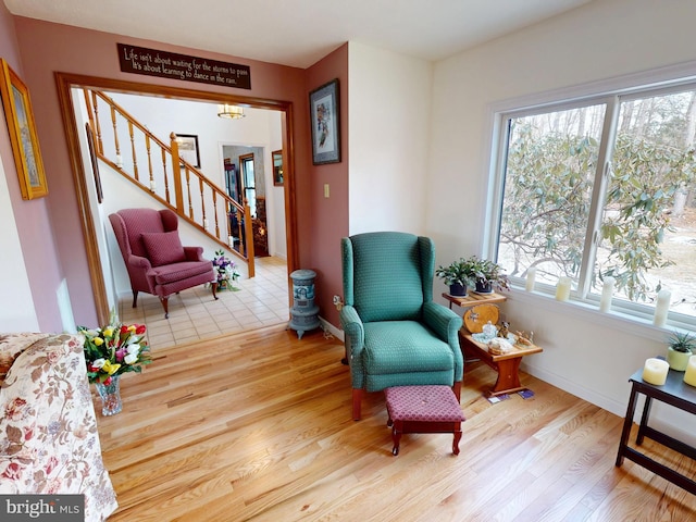 living area with stairs, baseboards, and wood finished floors