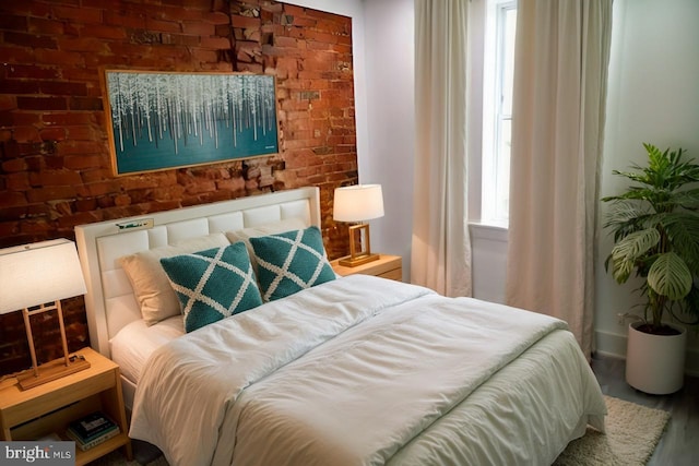 bedroom featuring brick wall