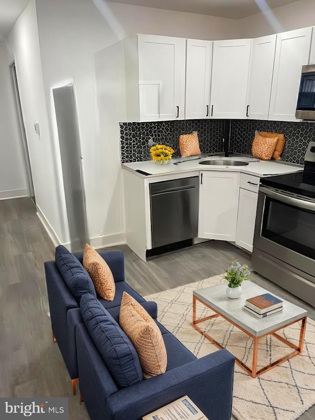 kitchen with tasteful backsplash, sink, stainless steel appliances, and white cabinets