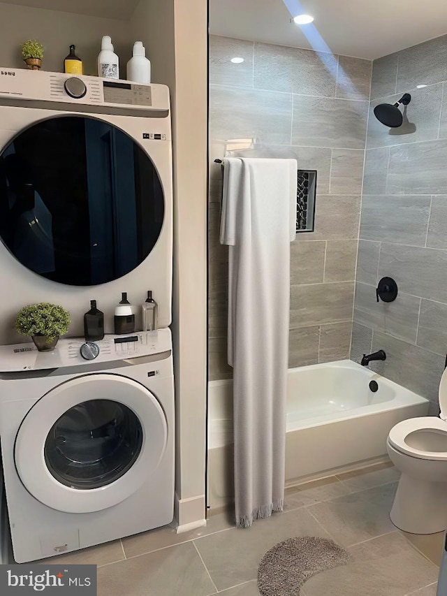 bathroom featuring washer / clothes dryer, tiled shower / bath, tile patterned flooring, and toilet