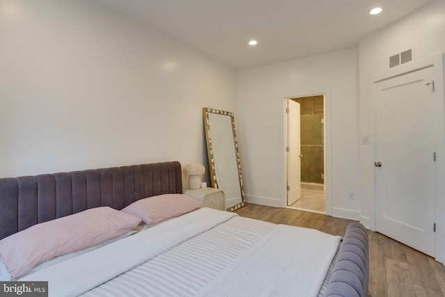 bedroom featuring ensuite bathroom, recessed lighting, wood finished floors, visible vents, and baseboards