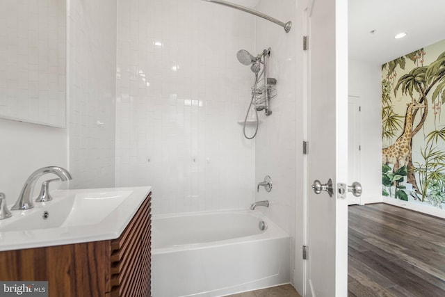 full bathroom featuring wood finished floors, vanity, and shower / bathtub combination