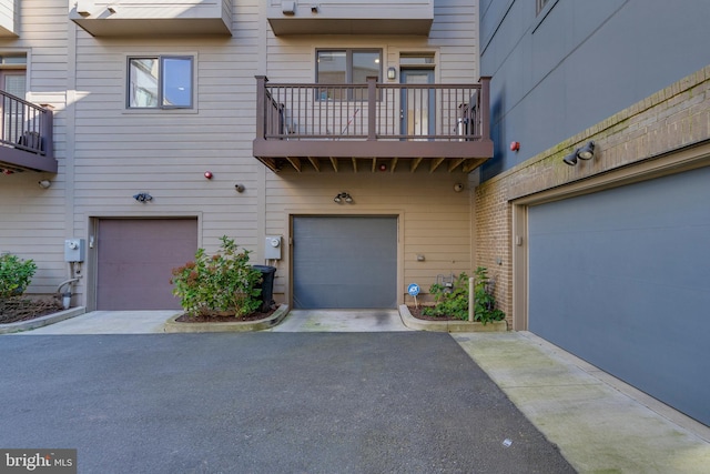 exterior space featuring a garage, driveway, and a balcony