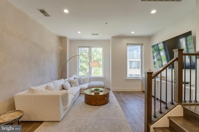 living area featuring recessed lighting, visible vents, stairway, and wood finished floors