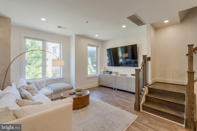 living area with recessed lighting, wood finished floors, visible vents, baseboards, and stairway