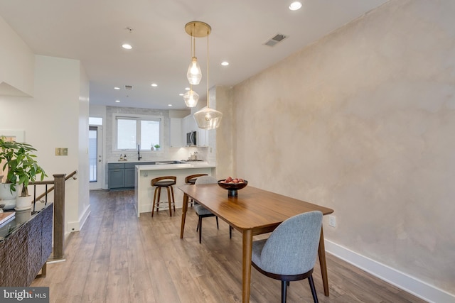 dining area with visible vents, baseboards, wood finished floors, and recessed lighting