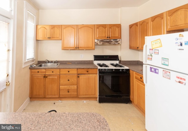 kitchen featuring sink, gas range, light tile patterned floors, and white fridge