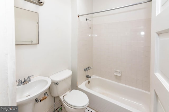 full bathroom with toilet, tiled shower / bath combo, and sink