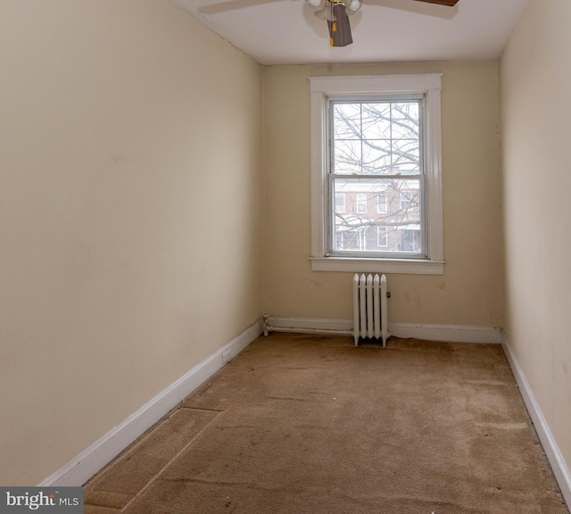 unfurnished room with ceiling fan, radiator heating unit, and light carpet