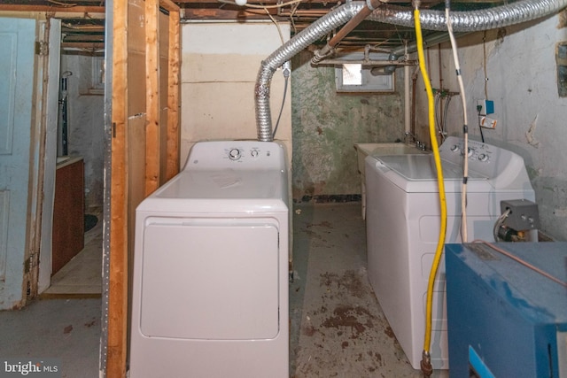 laundry area with separate washer and dryer and sink