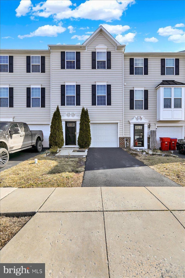 multi unit property featuring driveway and an attached garage