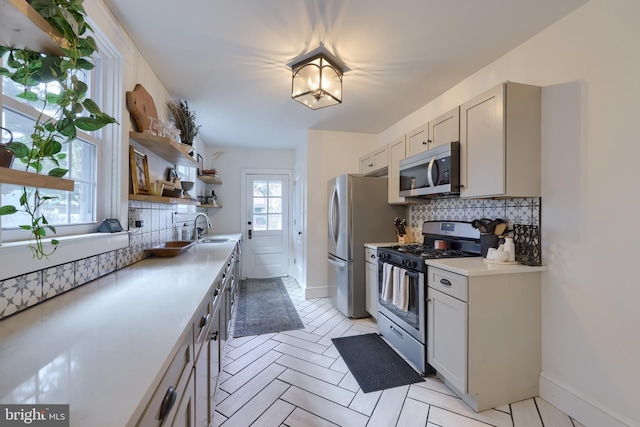 kitchen featuring stainless steel appliances, sink, and decorative backsplash