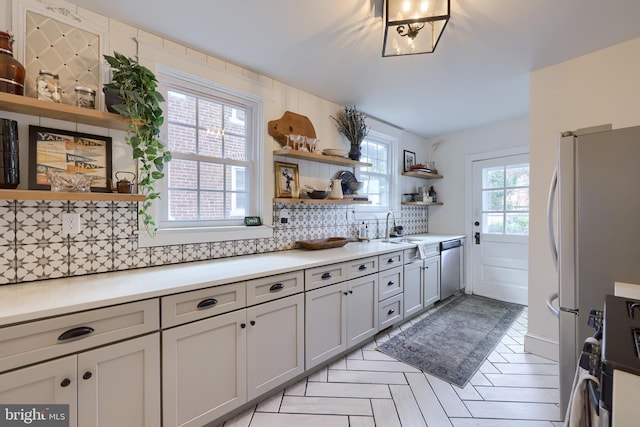 kitchen with stainless steel appliances, sink, and backsplash