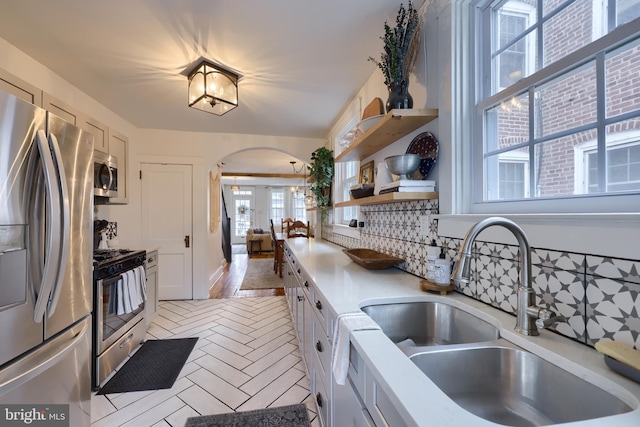 kitchen featuring stainless steel appliances, sink, and white cabinets