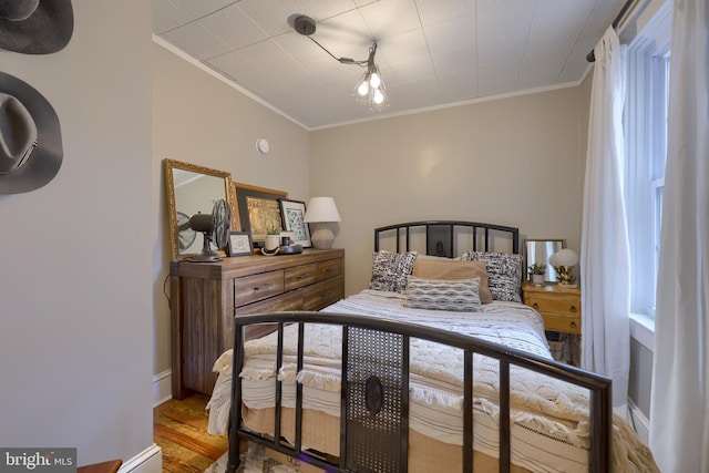 bedroom featuring hardwood / wood-style flooring and crown molding