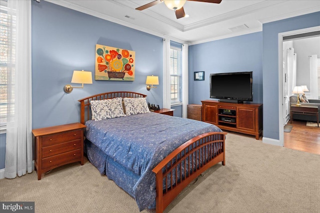 bedroom with a raised ceiling, ornamental molding, light carpet, and ceiling fan