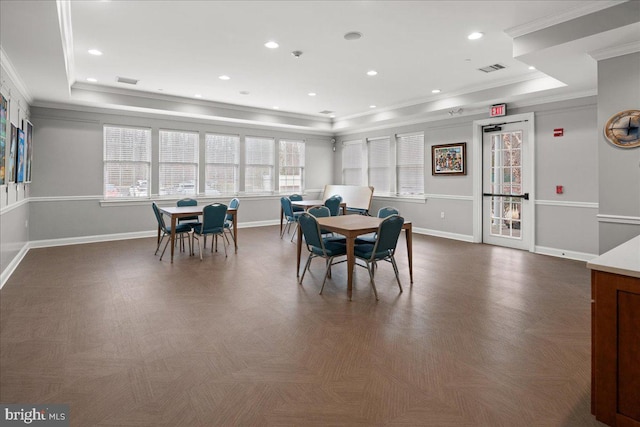 dining area with a tray ceiling, ornamental molding, and dark parquet flooring