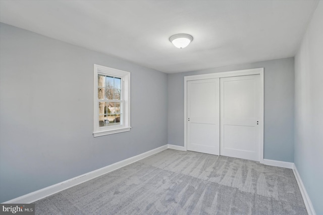 unfurnished bedroom with a closet and light carpet