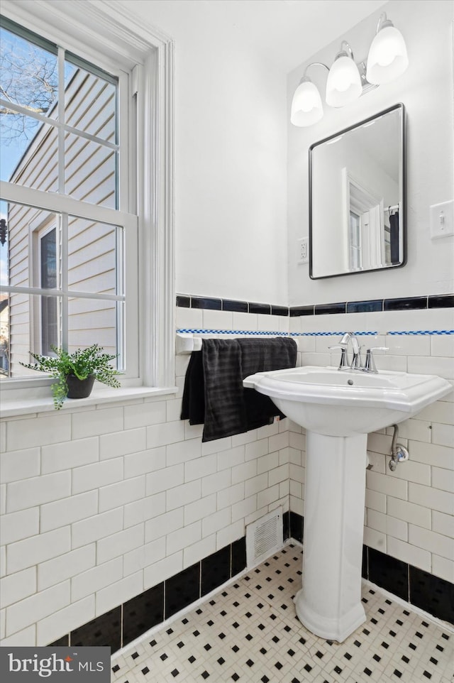 bathroom featuring tile patterned flooring and tile walls