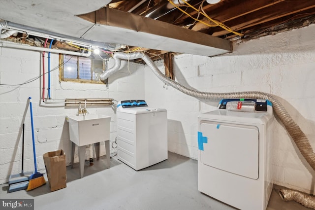 clothes washing area with separate washer and dryer and sink