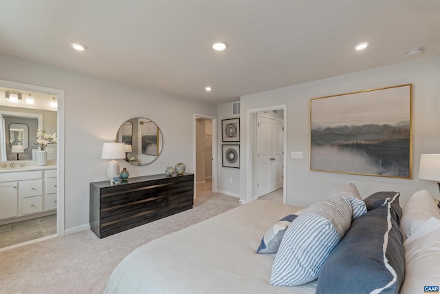 bedroom featuring stacked washer / drying machine, ensuite bathroom, sink, and light carpet