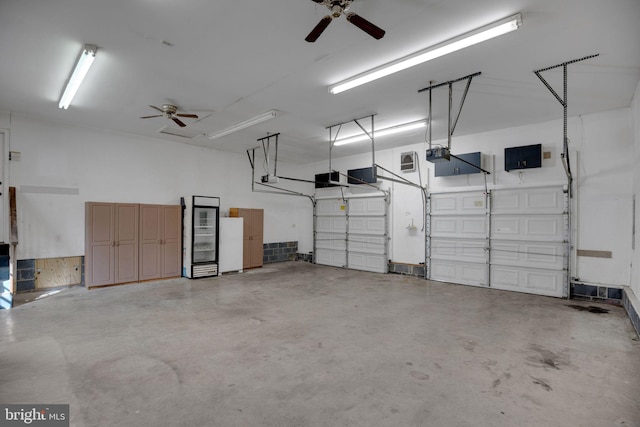 garage featuring a garage door opener, ceiling fan, and white refrigerator