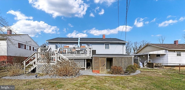 rear view of property featuring a wooden deck and a lawn