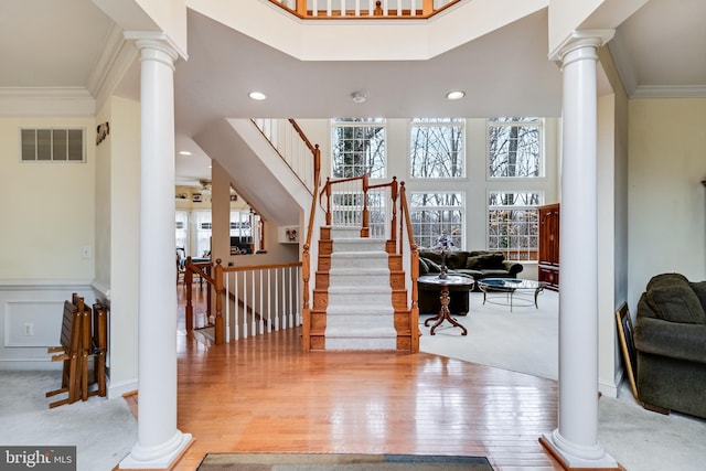 foyer entrance featuring crown molding, visible vents, and ornate columns