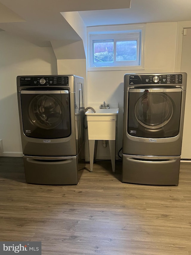 laundry room with light hardwood / wood-style flooring and washer and clothes dryer