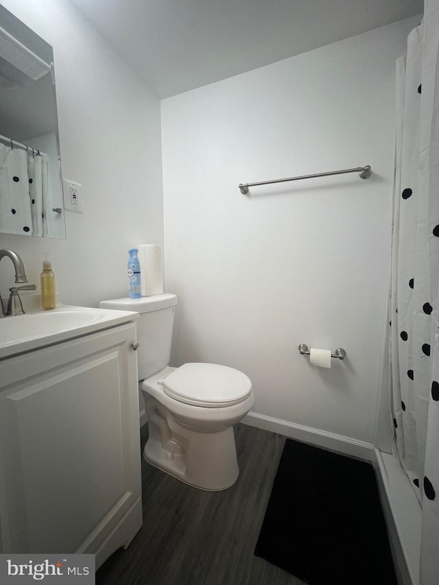 bathroom with vanity, hardwood / wood-style floors, toilet, and walk in shower