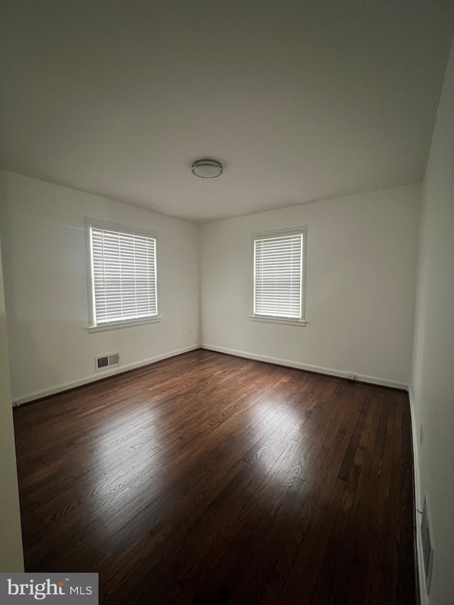 unfurnished room featuring dark hardwood / wood-style flooring