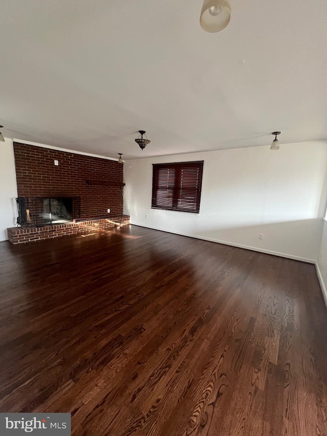 unfurnished living room featuring dark wood-type flooring and a fireplace