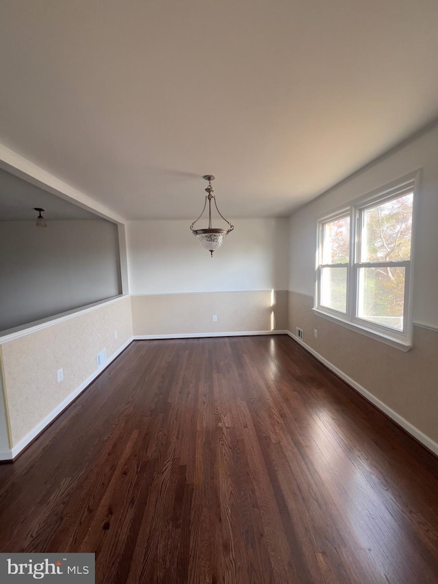 unfurnished dining area with dark wood-type flooring