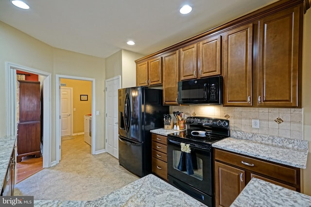 kitchen with recessed lighting, baseboards, decorative backsplash, light stone countertops, and black appliances