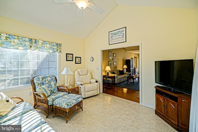 living room with high vaulted ceiling, ceiling fan, baseboards, and light tile patterned floors