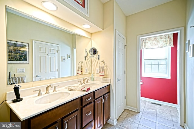 full bathroom with double vanity, tile patterned flooring, visible vents, and a sink