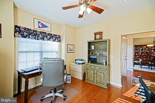 office area with a ceiling fan, baseboards, and wood finished floors