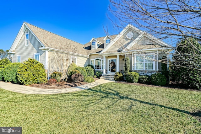 view of front of property featuring a shingled roof and a front lawn