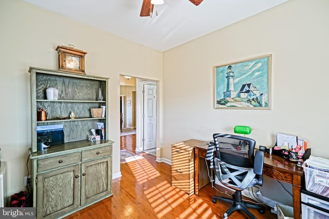 home office featuring light wood finished floors, ceiling fan, and baseboards