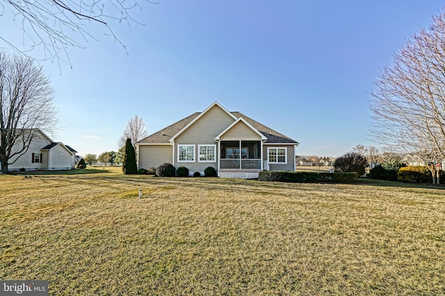 view of front of house with a front yard and a sunroom