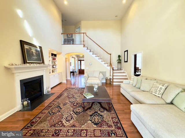 living room featuring dark wood-type flooring and built in shelves