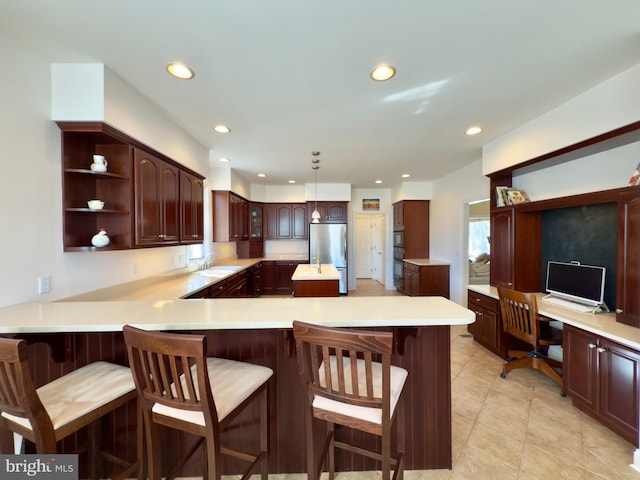 kitchen featuring stainless steel fridge, a kitchen breakfast bar, decorative light fixtures, and kitchen peninsula