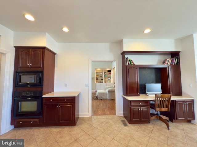 kitchen with light tile patterned flooring and black appliances