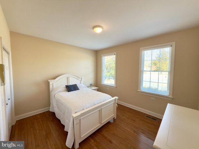 bedroom with dark hardwood / wood-style floors