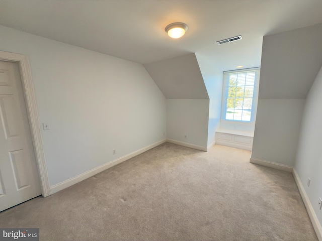 bonus room featuring vaulted ceiling and light colored carpet