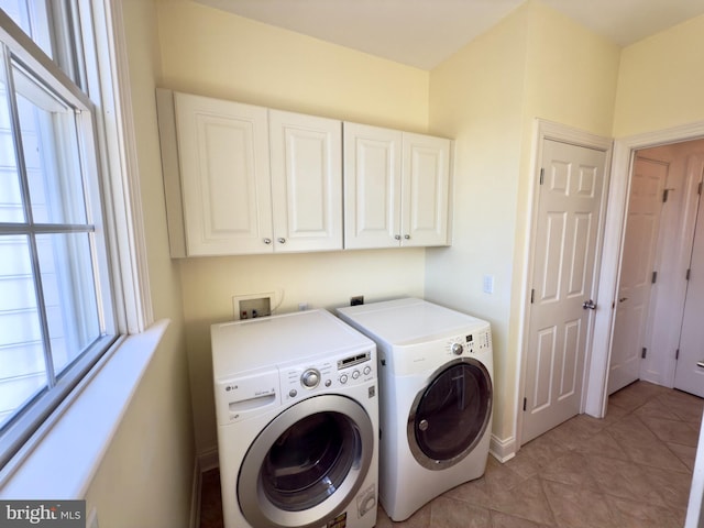 laundry room featuring cabinets, separate washer and dryer, and light tile patterned floors