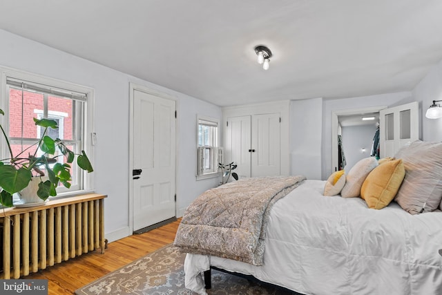 bedroom featuring radiator and wood finished floors